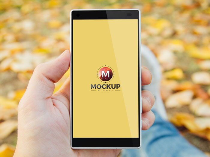 Free-Man-In-Park-Holding-Smartphone-Psd-Mockup