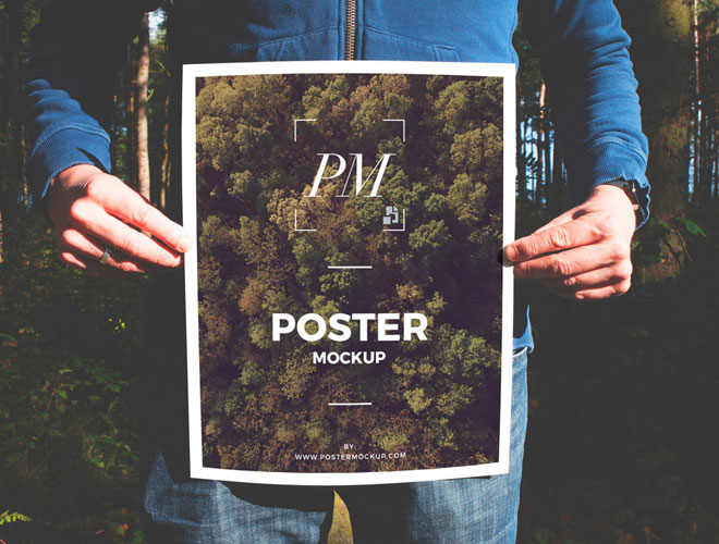 Man-in-Forest-Holding-Poster-Mockup-PSD